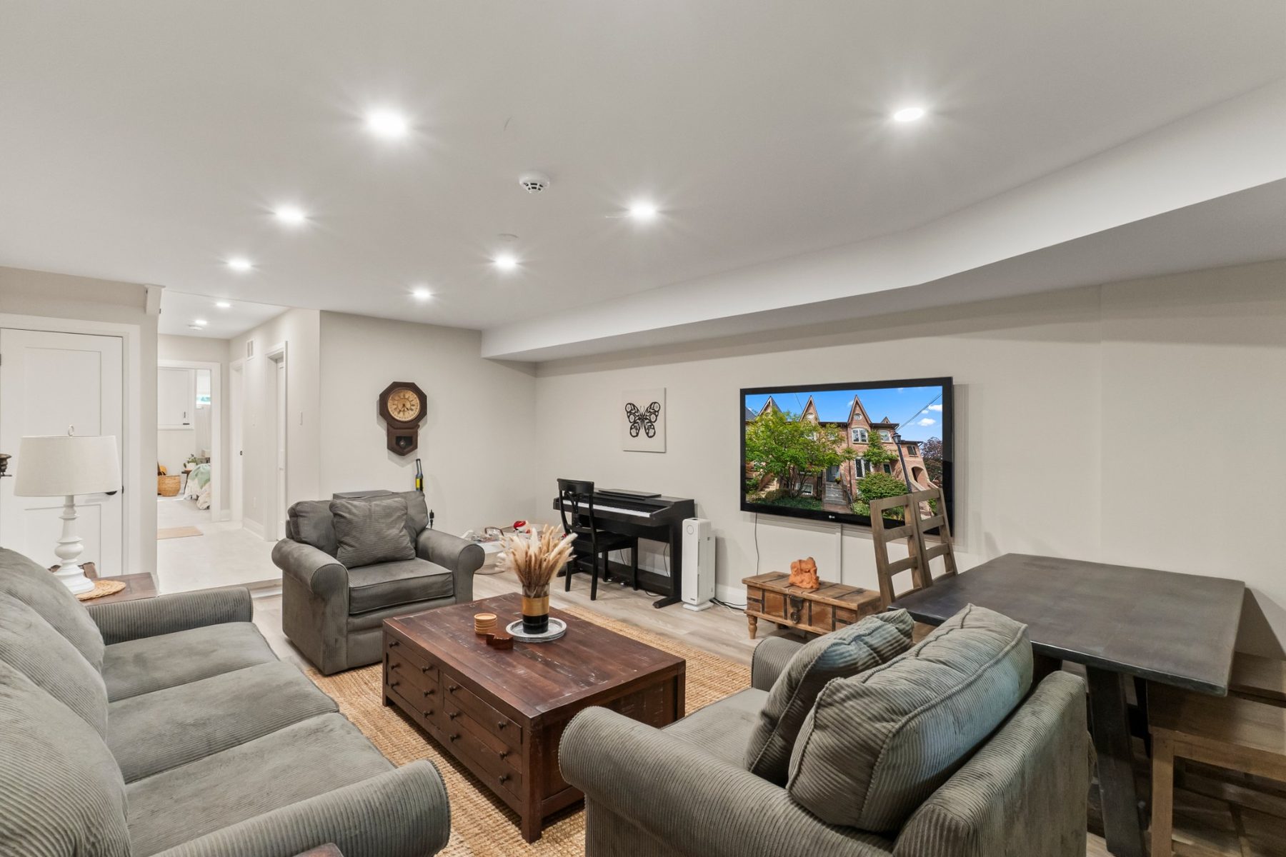Finished basement family room with pot lights and wide-plank flooring